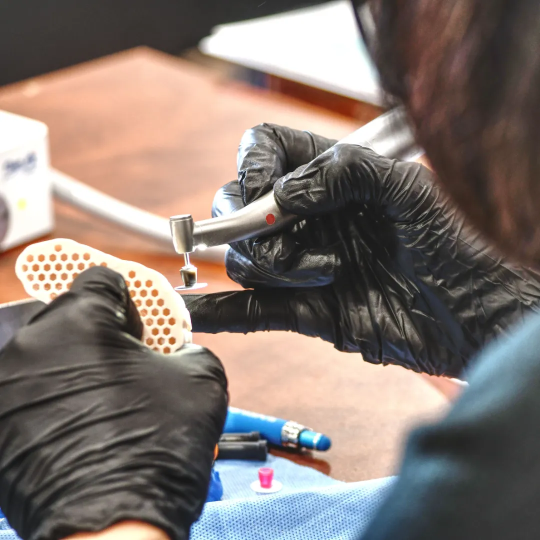 Dental professional using an electric handpiece during a clinical exercise